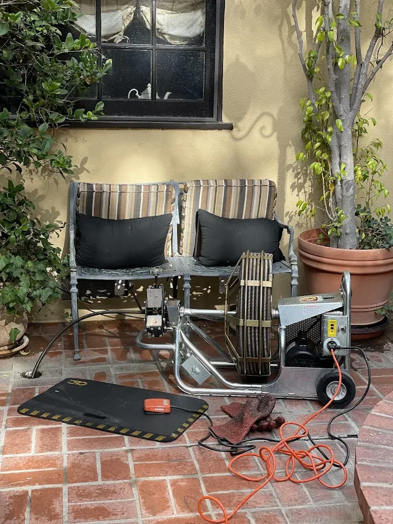 Drain-cleaning machine and cable equipment on a patio