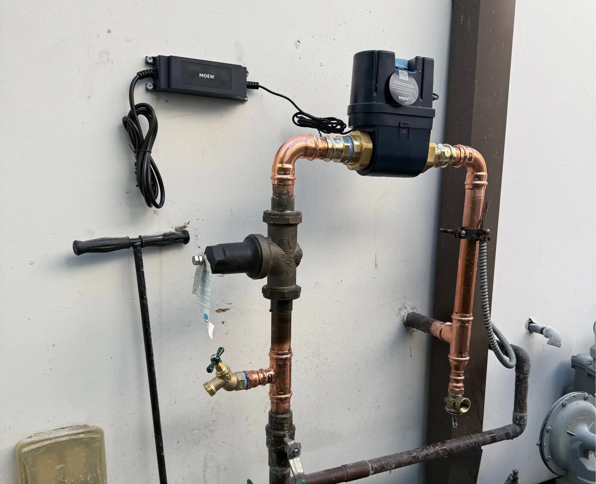 Smart water shutoff valve and pressure regulator on new copper piping along an exterior wall