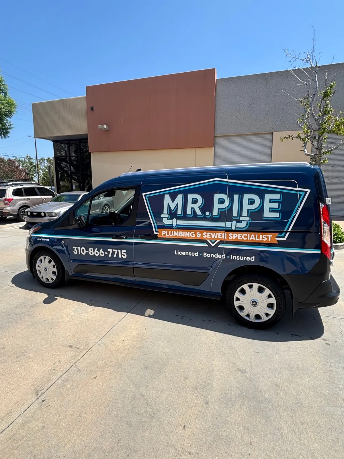 The Mr. Pipe Plumbing and Rooter service van, wrapped with the company logo, phone number, and license number