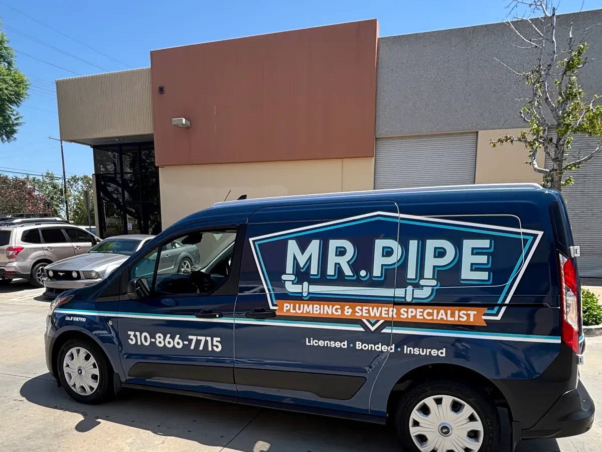 The Mr. Pipe Plumbing service van, wrapped with the company name, the office phone number, and license number 1087910