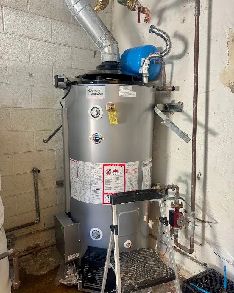 A seismic-strapped tank water heater with its flue, thermal expansion tank and recirculation pump, plumbed in a utility room